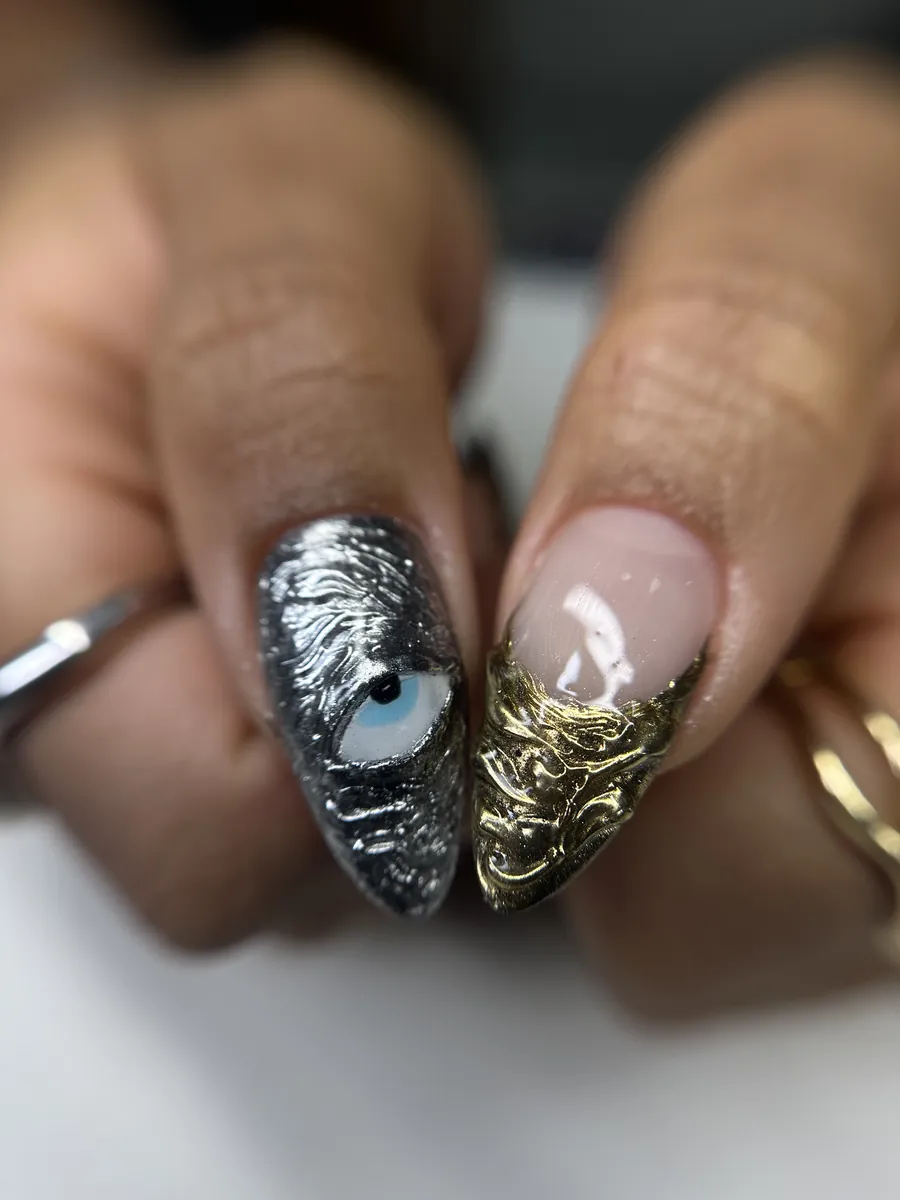 Unhas da Beatriz Concept em efeito cromado: uma prateada com olho grego e outra com ponta dourada texturizada